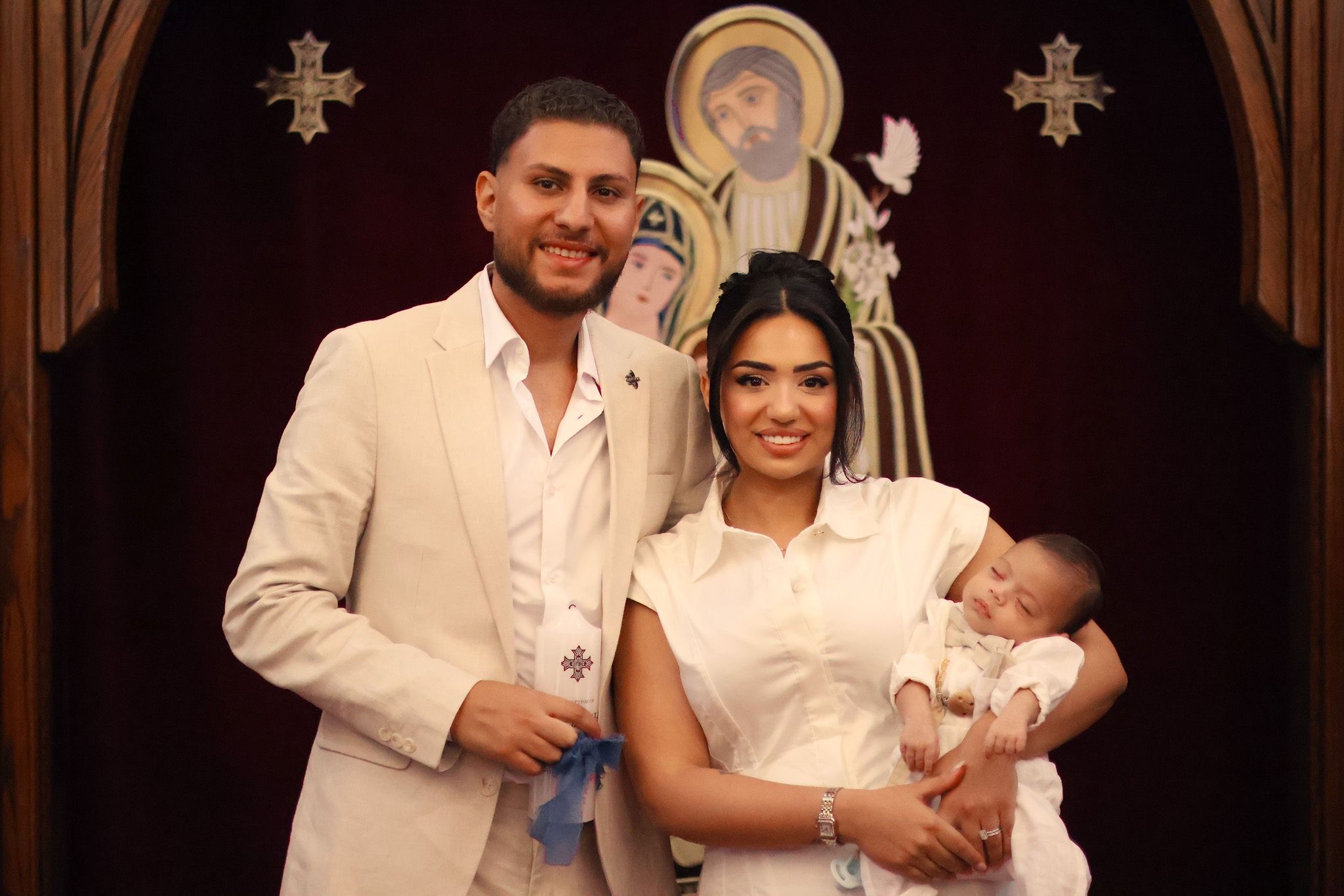 Parents holding their baby during a christening