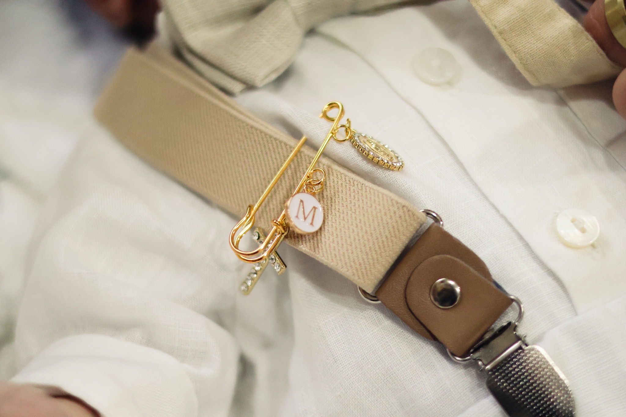 Close-up of a christening pin and outfit detail