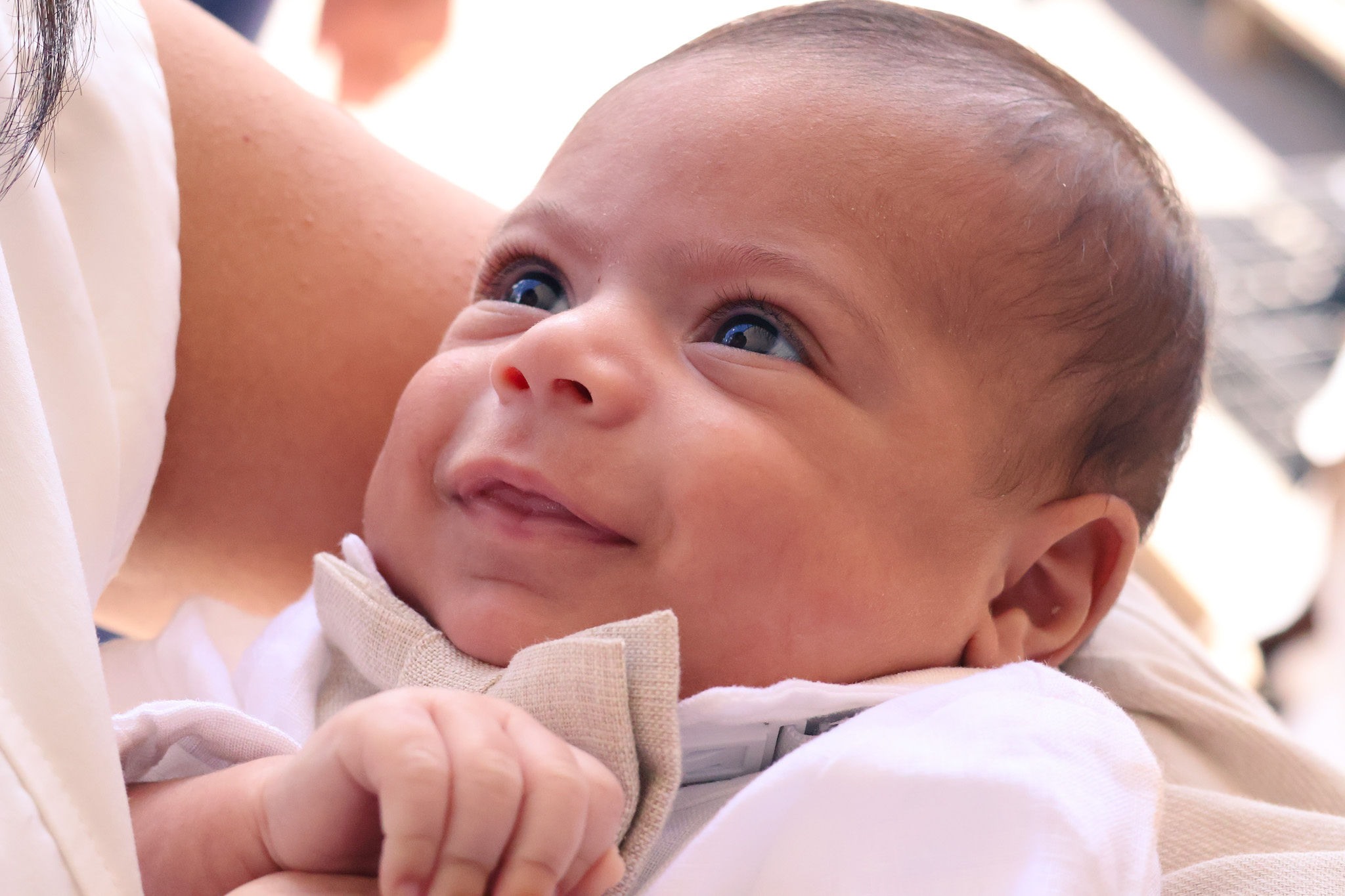 Smiling baby photographed during a christening celebration