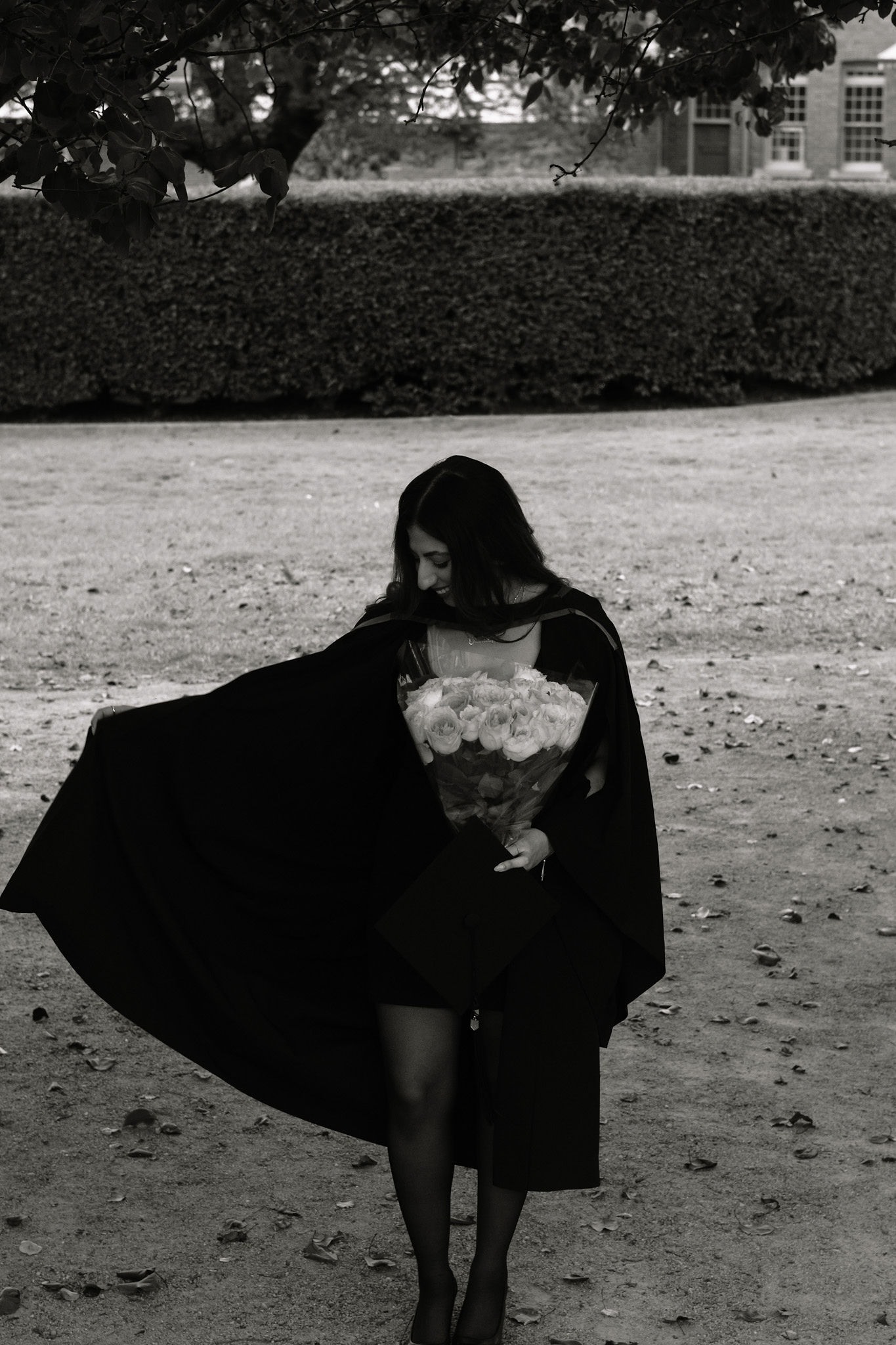 Black and white graduation portrait with flowing gown