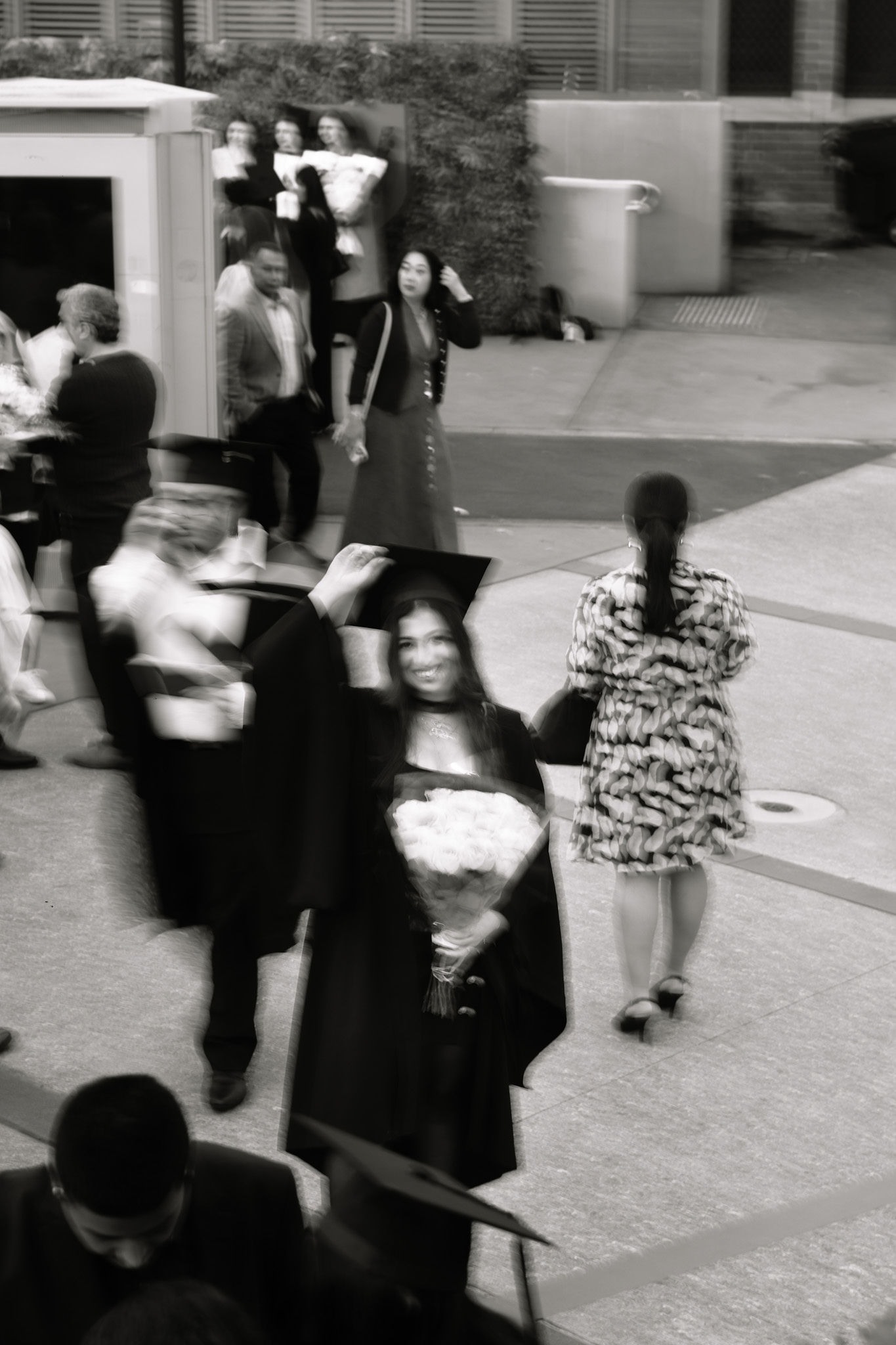 Black and white motion photograph of a graduate among people