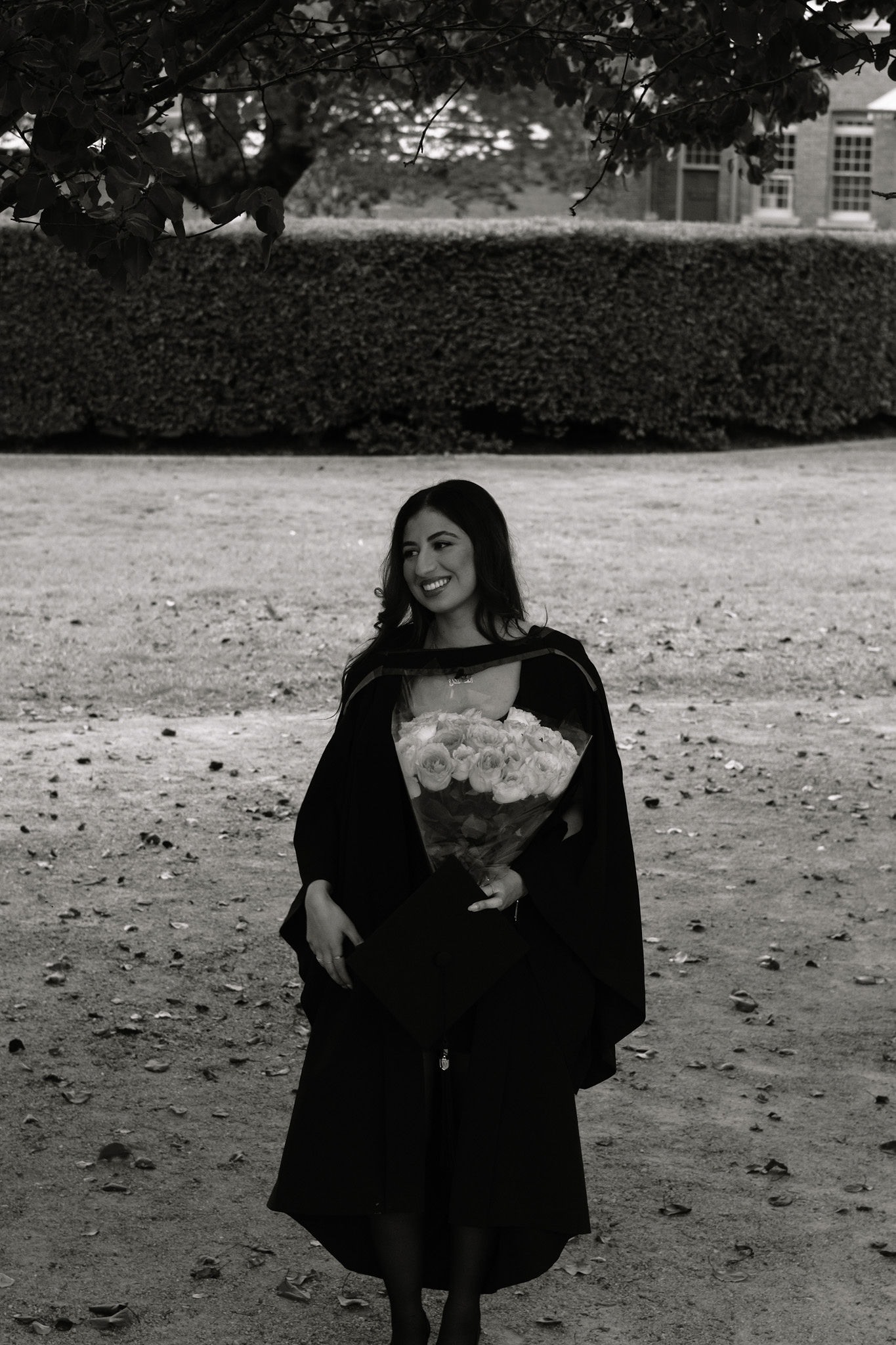 Black and white graduation portrait holding flowers