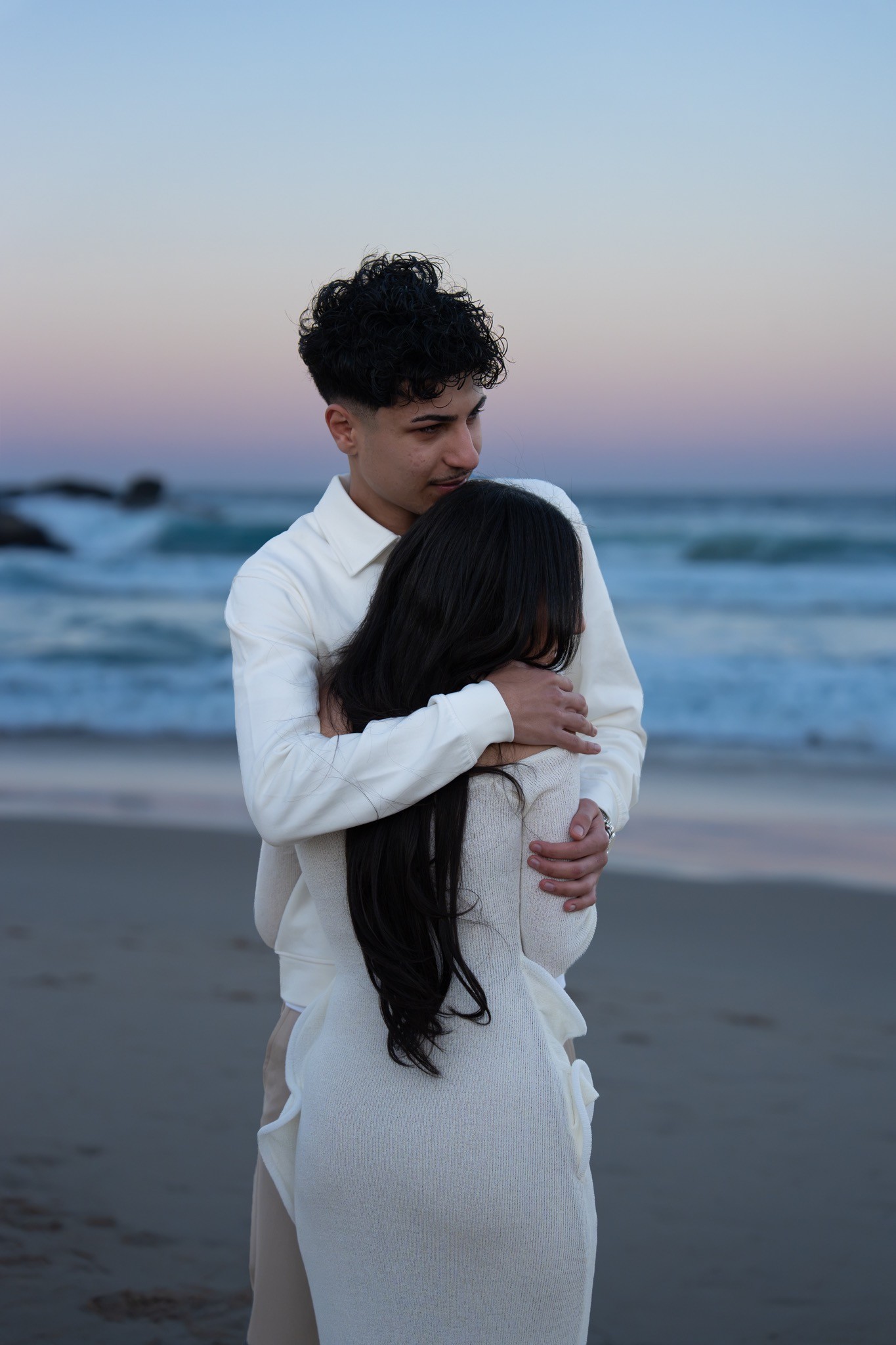 Couple embracing on the beach at dusk