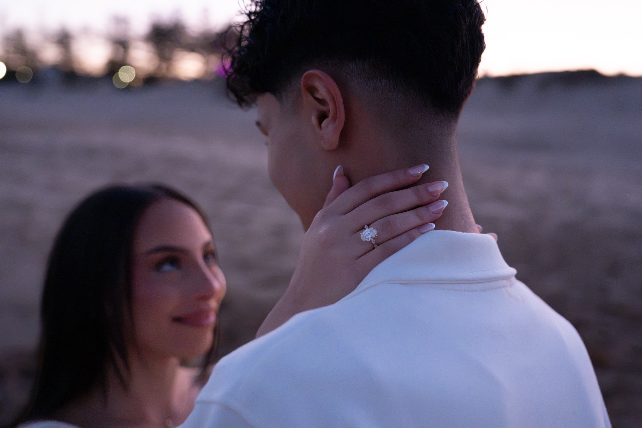 Engagement ring shown over the groom-to-be's shoulder